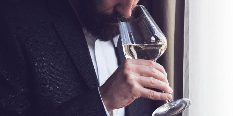 a man sniffing a glass of white wine during a wine tasting
