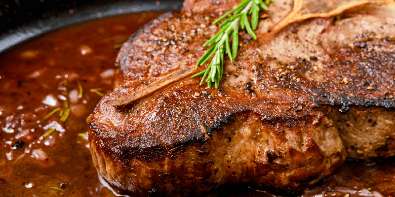 a picture of a cooked porterhouse steak on a plate