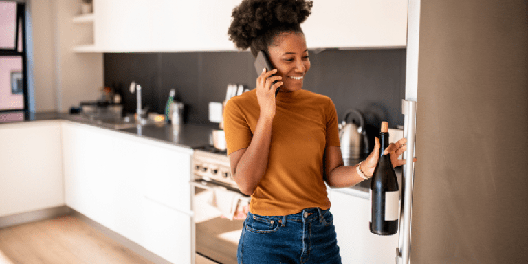 women getting an opened bottle of wine from her refrigerator