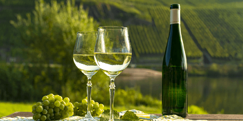 two wine glasses and a bottle of riesling wine