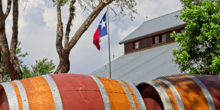 a barrel of wine next to the texas flag