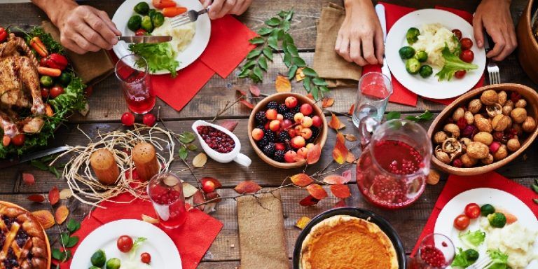 a table full of thanksgiving dishes like cranberry sauce, sweet potato casserole, and turkey