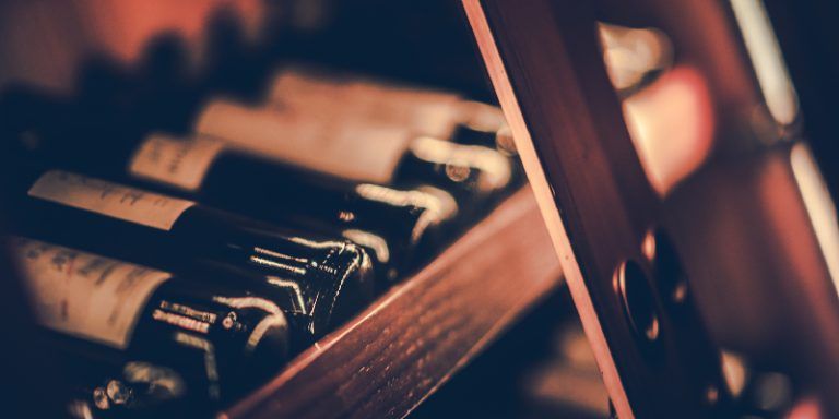 Bottles of red wine laying horizontally on a wine rack