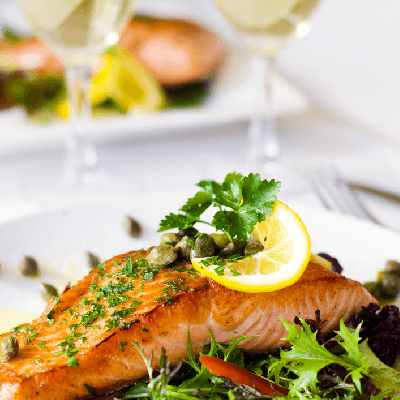 baked salmon dish with a glass of white wine
