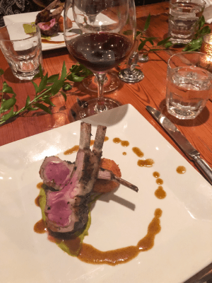a lamb chop served with a glass of red wine