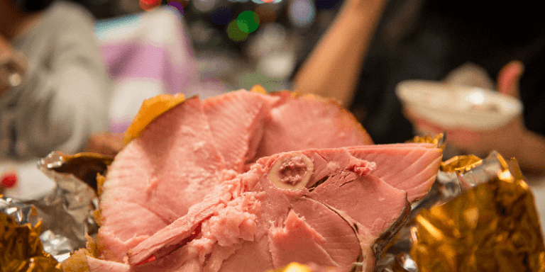 a honey baked ham being served for Christmas dinner