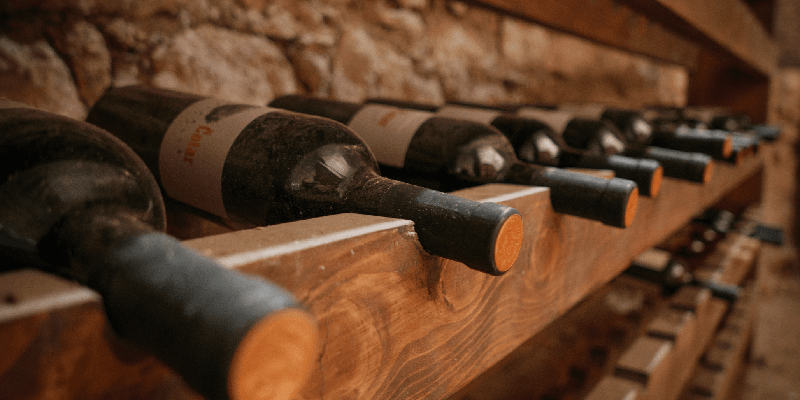 wine bottles being stored on a wooden wine rack