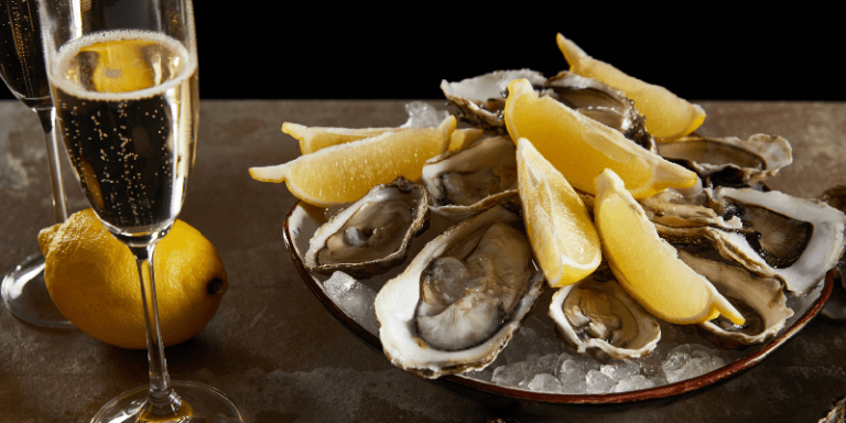 a plate of oysters with a glass of champagne